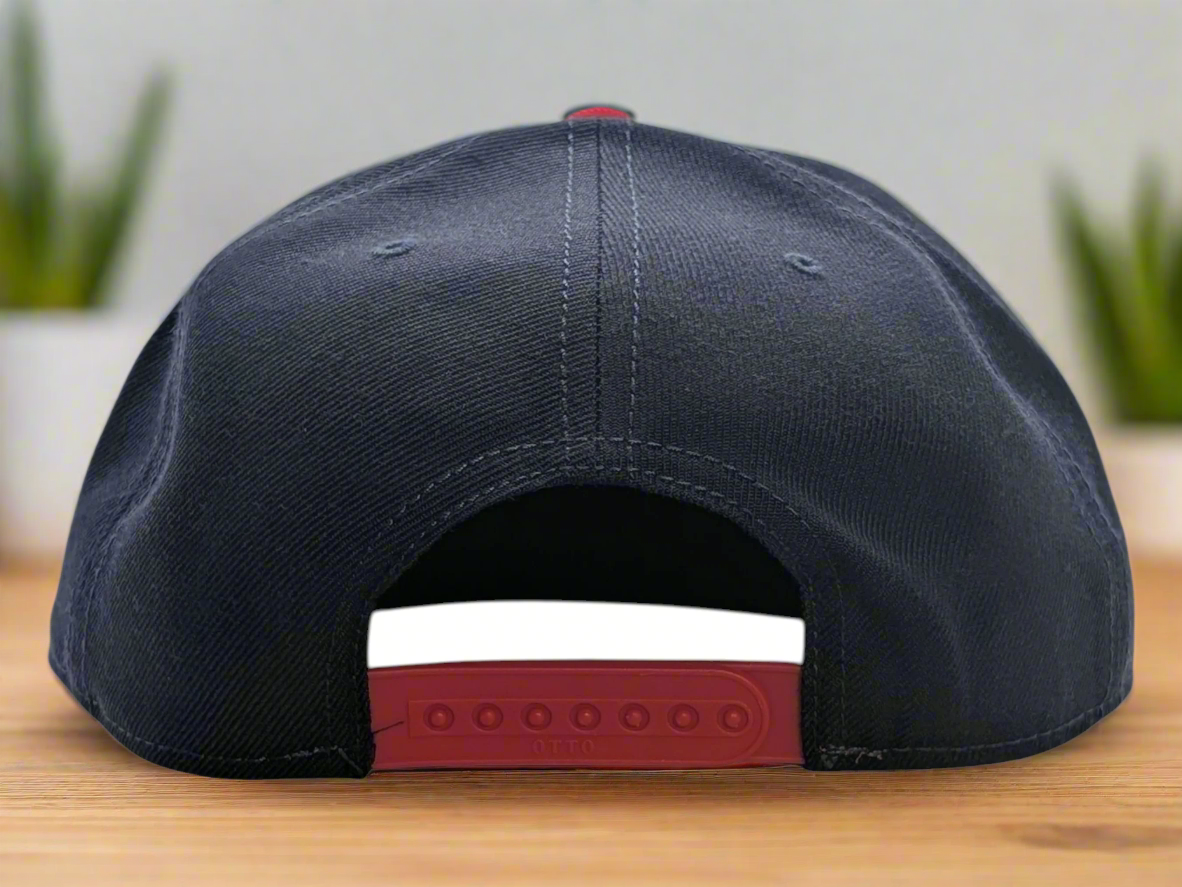Black cap with red interior and strap on a white background